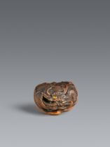 A Tanba boxwood netsuke of a dragon inside a mikan. Mid-19th century