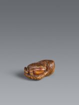 An Ise-Yamada boxwood netsuke of a toad next to a rock. 19th century