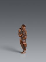 A boxwood netsuke of a Chinese fisherman with two fish. 18/early 19th century