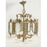 A large ornate brass light fitting with etched glass panels. 46x69cm