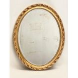 An oval gilt framed mirror. 58x63cm