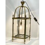 A large late 19th/ early 20th century heavy brass electrified lantern with bevelled glass panels.