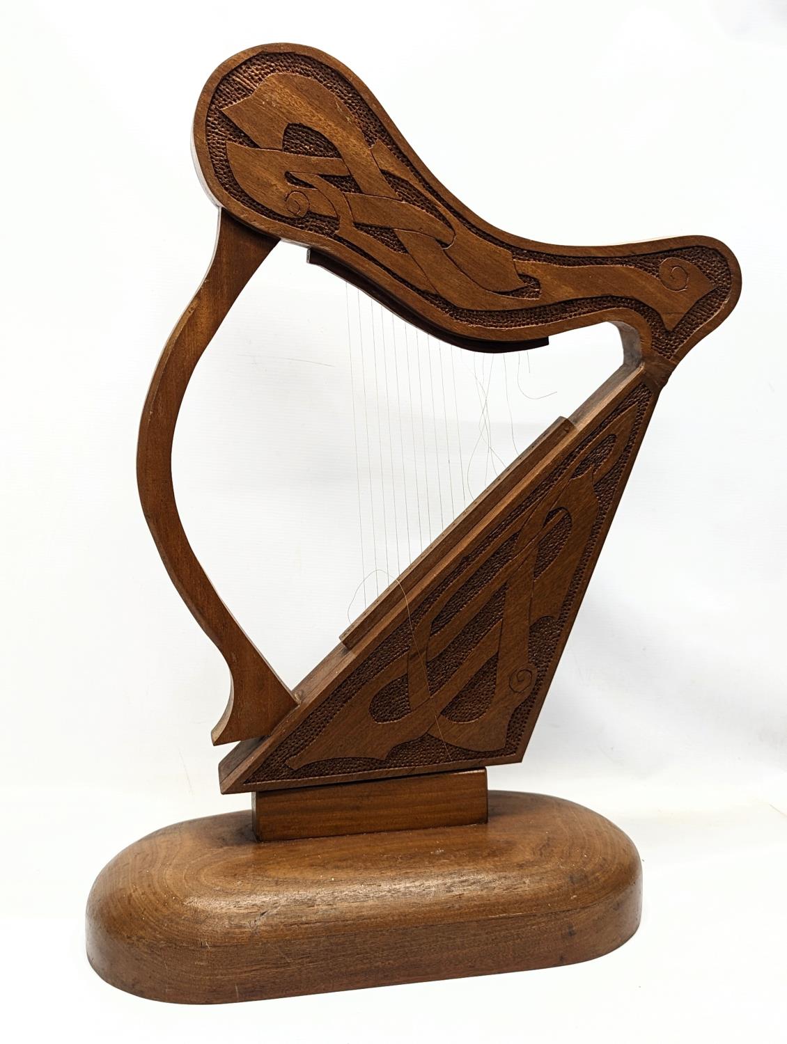 A large carved walnut ornamental harp with Celtic engraving. 75.5x48cm