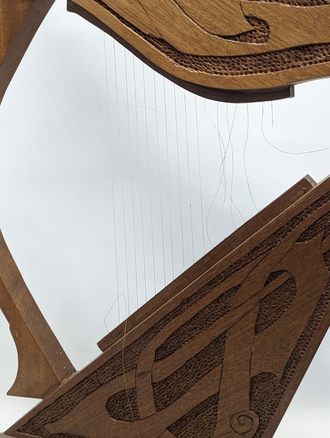 A large carved walnut ornamental harp with Celtic engraving. 75.5x48cm - Image 3 of 3