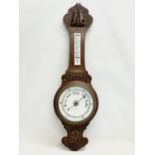 An Edwardian carved oak barometer. Presented to Mr A. Maguinness by the staff of Londonderry Prison,