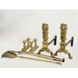 Early 20th century brass fire andirons and tools. Tools measure 78cm. Lion andirons measure
