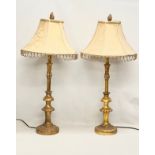 A pair of tall ornate gilt table lamps. 85cm