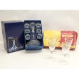 A crystal decanter with 6 drinking glasses with a set of 4 sherry glasses.