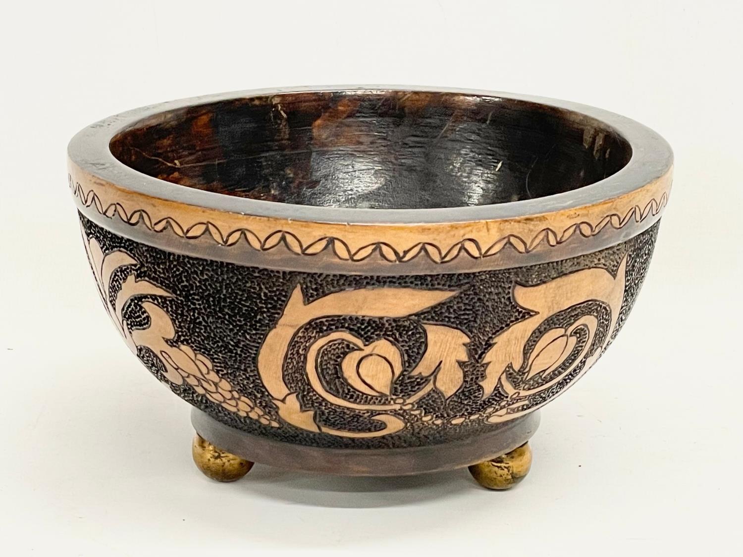 An early 20th century wooden Pokerwork bowl on brass feet. 19.5x11cm