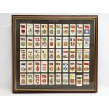 A framed collection of vintage John Players & Sons cigarette cards, National Flags and Arms. 51.