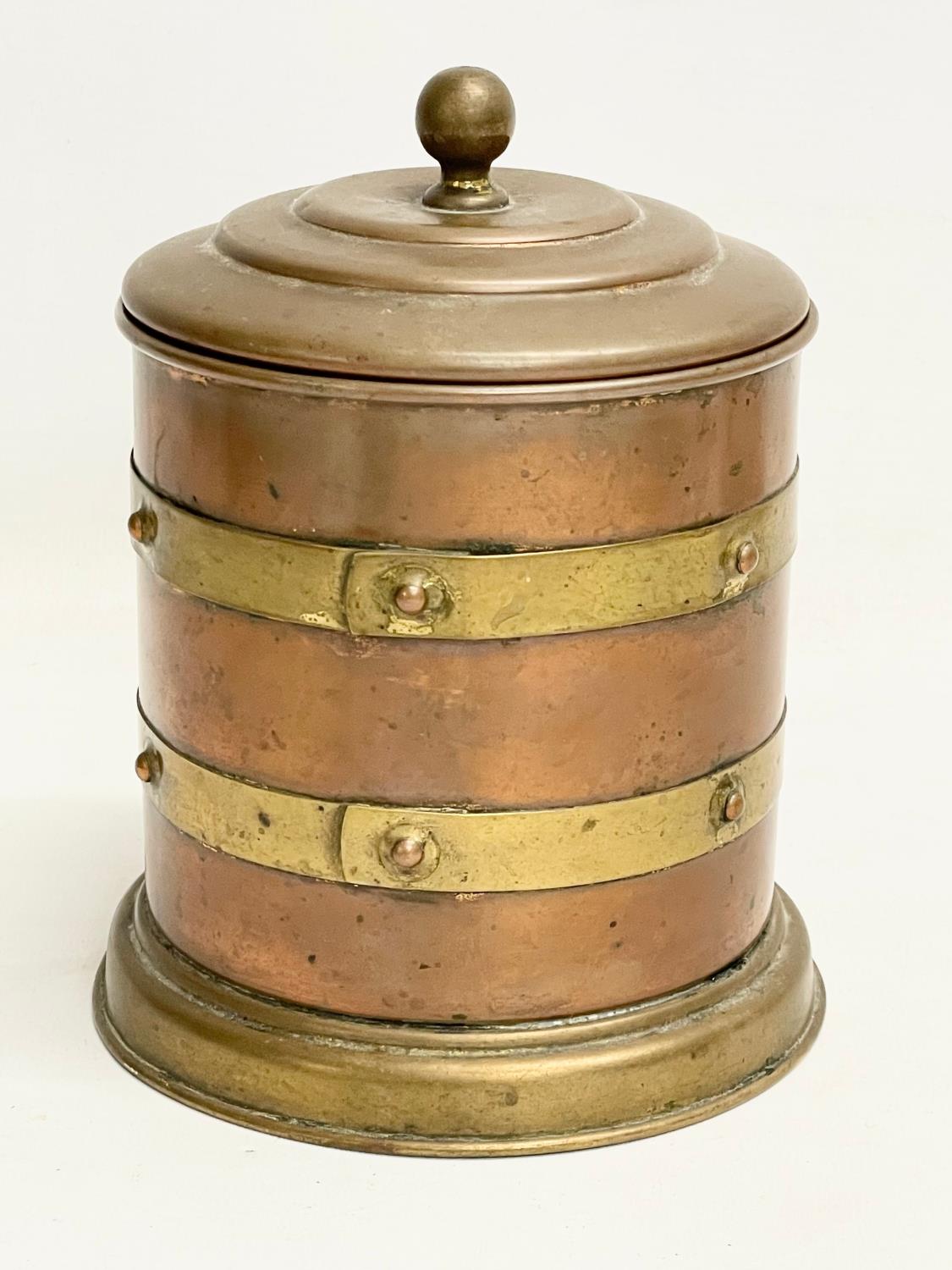 An early 20th century copper and brass tobacco tin. 12x16cm