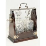 A vintage mahogany and silver plated tantalus with a pair of crystal decanters. 25x13x31cm