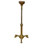A large Victorian brass candle stand on lion paw feet