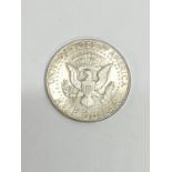 A 1964 silver half dollar.