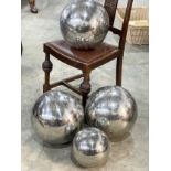 4 stainless steel ornamental spheres. Largest three measure 33x33cm