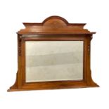 An Edwardian walnut over-mantle with a bevelled mirror. 120x91cm
