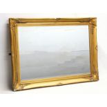 An ornate gilt framed bevelled mirror. 90x64.5cm