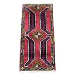 A vintage Middle Eastern hand knotted rug. 49x105cm