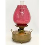 A large late Victorian brass double burner oil lamp with Ruby Glass shade. 30x52cm