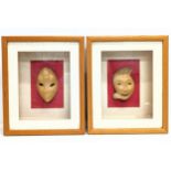 A pair of wooden masks in shadow box frames. 34.5x42cm