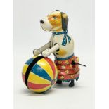 A vintage tinplate windup dog with ball. 11x11cm