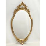 An ornate gilt framed mirror. 43x83cm