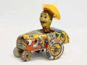 A vintage tin plate ‘Crazy Cowboy’ windup toy. Made in Great Britain. 16x16cm