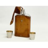 An early 20th century leather bound hip flask and 2 cups. 17cm