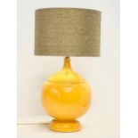 A large Mid Century mustard glazed pottery table lamp. Base measures 23x35cm without shade.