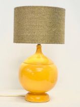 A large Mid Century mustard glazed pottery table lamp. Base measures 23x35cm without shade.