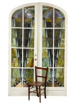 A pair of very large early 20th century Art Deco ornate stained glass arched doors. each door