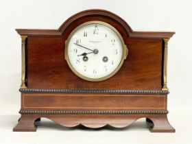 A late Edwardian inlaid mahogany mantle clock with brass mounts, key and pendulum. Riddles