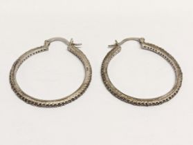 A pair of silver hoop earrings.
