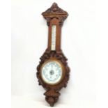 A large Victorian carved oak Barometer. 99.5cm