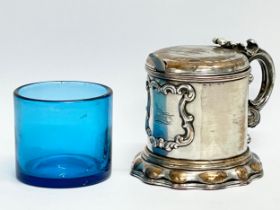 A 19th century ornate silver plated mustard pot with original Bristol Blue liner. 10x8x7cm