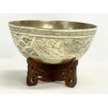 A large early 20th century Chinese brass bowl on wooden stand. Bowl measures 24x11cm.