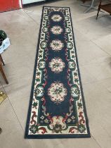 A large wool runner rug. 330x70cm