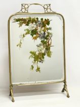 An Edwardian brass framed mirrored firescreen with hand painted flower decoration. 46x18x73cm