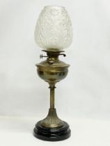 A tall Victorian brass double burner oil lamp with later glass shade. 62cm