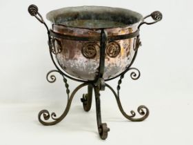 A large late 19th century Art Nouveau copper planter in the original wrought iron base. 49x45x44cm