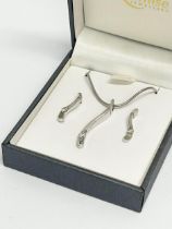 A silver necklace and matching earrings.