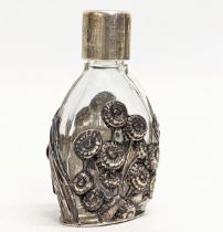 An ornate silver and glass scent bottle. 7cm