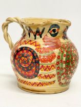 A vintage glazed stoneware jug with twist handle and hand painted decoration. 23x18cm