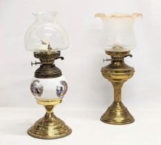 A vintage brass oil lamp with another vintage brass and pottery oil lamp. With glass shades. Tallest