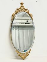 A vintage ornate gilt framed bevelled mirror. 33x75.5cm