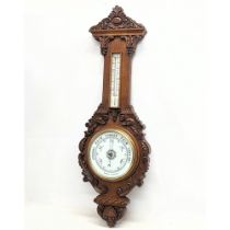 A large Victorian carved oak Barometer. 99.5cm