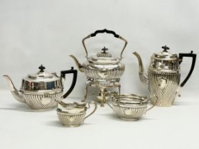 A 5 piece silver plated tea service. Including a spirit kettle 23x30cm. A coffee pot 24.5x24cm.