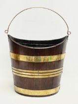 A George III brass bound mahogany peat bucket with original liner. Circa 1800. 37x27x37cm