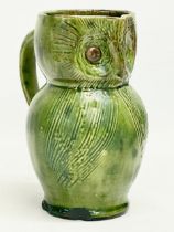 A late 19th century Farnham Pottery green glazed earthenware owl jug. 12x14cm.