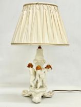 A Belleek pottery cherub lamp. Blue stamp. Base measures 18x32cm. 51cm with shade.